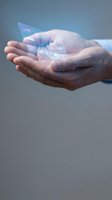 Male hands holding holographic digital card with glowing data visualization, representing fintech innovation, digital payment technology, and future banking solutions.
