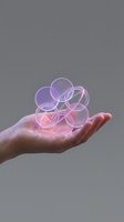 Hand holding glowing transparent spheres with pink purple light effects on gray background for digital technology concepts.