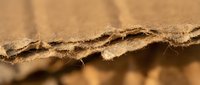 Corrugated cardboard edge showing detailed texture and layers of recycled paper material for packaging and shipping applications.