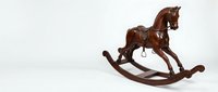 Vintage wooden rocking horse with rich mahogany finish, isolated on white background, a classic antique toy for nursery and retro decor themes.