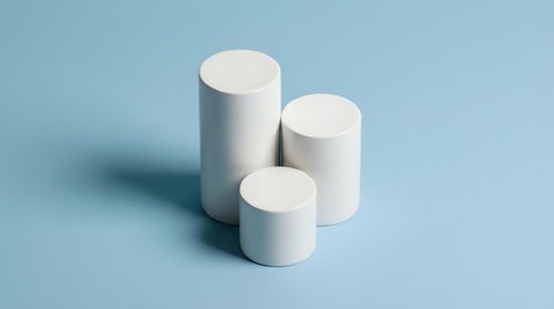 White cylindrical geometric shapes in ascending height arrangement on soft blue background for modern minimalist design and product display.