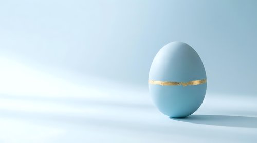 Light blue Easter egg with golden band on clean white background for spring holiday decorations and greeting cards.