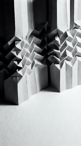 Abstract geometric paper sculpture with angular folded forms creating dramatic shadows and depth in monochrome composition for modern design projects.