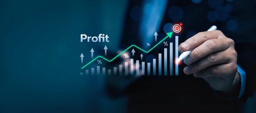 Businessman hand drawing upward profit growth chart with glowing digital interface showing financial success and business analytics on dark blue background.