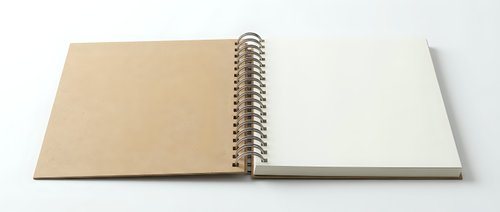 Open spiral-bound notebook with blank kraft paper and white pages on clean background for creative projects and note-taking applications.