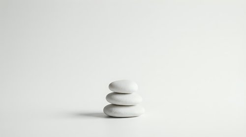Zen stone stack on minimalist white background for meditation wellness spa and balance concepts in clean modern style.