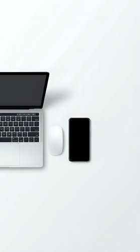 Modern workspace with laptop computer, smartphone and wireless mouse on clean white desk surface for business and technology projects.
