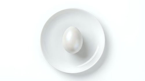 White chicken egg in ceramic bowl on white background isolated for cooking and food design projects.