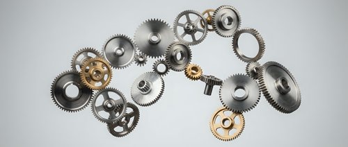 Mechanical gears and cogs floating in space with metallic finish for industrial design concepts and engineering projects on neutral background.