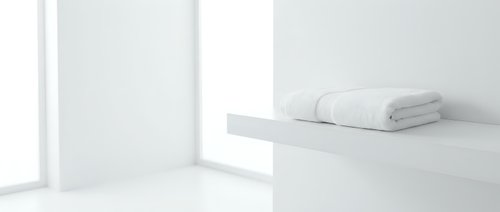 Folded white towels stacked on minimalist shelf in bright, clean bathroom interior with natural light from window.