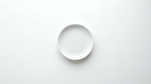 Empty white ceramic plate on clean white background for kitchen and dining design projects.