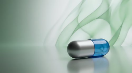 Medical capsule pill with flowing green smoke abstract background for pharmaceutical healthcare concepts.