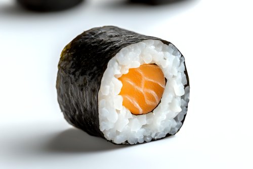 Fresh salmon maki sushi roll with rice and nori seaweed on white background, close-up view showing texture and ingredients for food photography.
