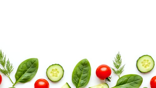 Fresh vegetables border with spinach leaves, cucumber slices, cherry tomatoes and dill herbs on white background for healthy cooking and nutrition.