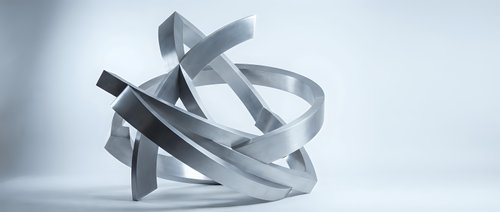 Abstract metallic ribbons twisted in dynamic sculptural form on white background for modern design projects and contemporary art concepts.
