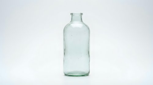 Empty clear glass bottle isolated on white background for packaging design and product mockup applications.