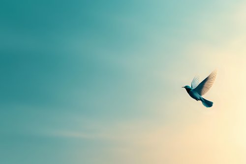 Silhouette of small bird flying against dreamy turquoise and cream sky background, wings spread in graceful motion, creating peaceful minimalist scene.