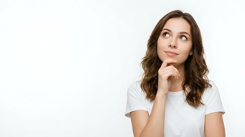 Young brunette woman in white t-shirt looking up thoughtfully with hand on chin, contemplating ideas against clean background for business content.