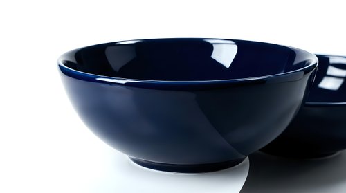 Deep navy blue ceramic bowls with glossy finish on white background, showcasing elegant kitchenware for food styling and product photography.