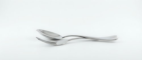 Two stainless steel spoons crossed together on a white background, isolated cutlery set with sleek modern design for kitchen and dining concepts.