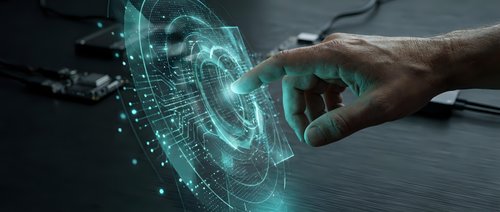Human hand touching futuristic holographic interface with glowing cyan digital elements and data visualization on dark surface for technology concepts.