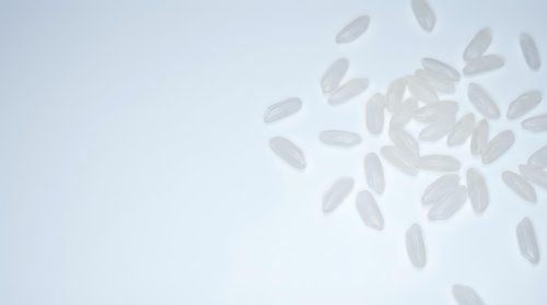 Scattered translucent white petals floating against a soft neutral background, suitable for wellness, spa, and cosmetic product marketing materials.