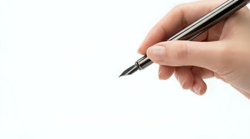 Hand holding elegant black fountain pen ready to write on clean white paper background for business correspondence and formal documents.