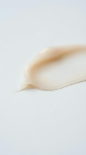 Smooth cream cosmetic texture stroke on white background for skincare and beauty product applications.
