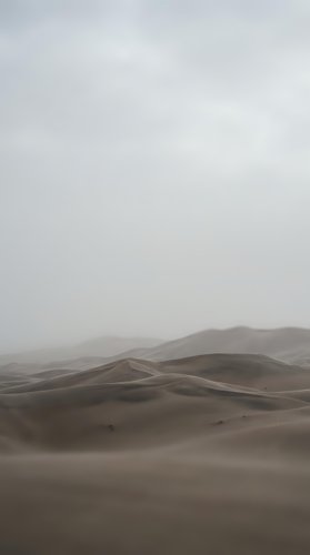 Misty desert landscape with rolling sand dunes fading into fog, creating a moody, minimalist atmosphere. Suitable for backgrounds, travel concepts, and nature publications.