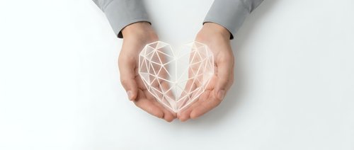 Hands cupping glowing geometric heart shape with network connections, symbolizing love, care, protection and digital wellness concepts.