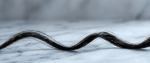 Abstract flowing black wave pattern on white marble surface creating elegant minimalist design for modern interior decoration and graphic projects.