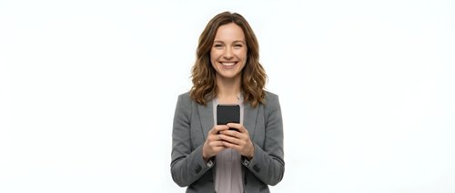 Smiling woman with long brown wavy hair, Caucasian ethnicity, wearing gray blazer, holding smartphone, isolated on white background for business and technology use.