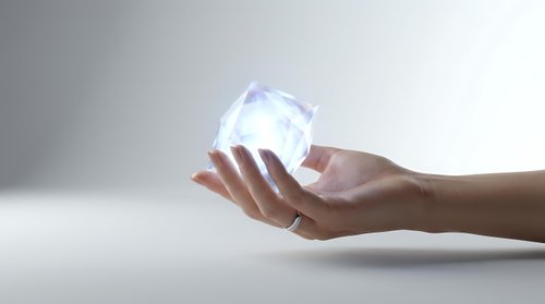 Female hands holding glowing transparent crystal sphere with magical light effects on clean white background for spiritual and energy concepts.