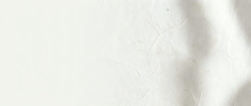 Soft beige fabric texture with delicate wrinkles and natural lighting shadows creating elegant minimalist background for fashion and interior design projects.
