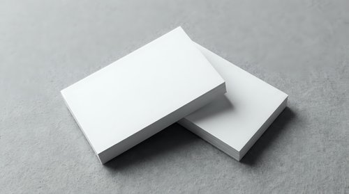 Blank white business cards mockup on gray textured surface for branding and corporate identity design projects.