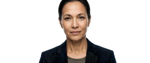 Professional middle-aged Hispanic businesswoman in dark suit jacket isolated on white background for corporate presentations and marketing materials.