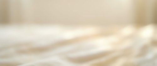 Abstract blurred beige and cream background with soft bokeh light effects for elegant design projects and presentations.
