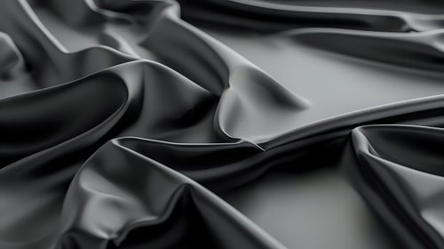 Elegant black silk fabric with soft waves and folds creating luxurious texture and dramatic shadows on dark background, suitable for fashion and luxury design projects.