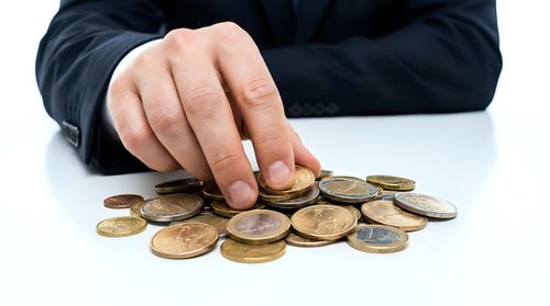 Businessman hand counting euro coins on white table, financial savings, budget management, and money concept.
