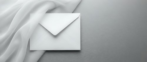 White envelope on soft fabric background with elegant shadows and minimalist composition for business correspondence and mailing concepts.