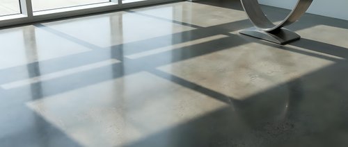 Modern polished concrete floor with natural sunlight casting geometric window shadows creating abstract patterns in minimalist interior space.