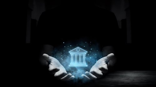 Businessman hands presenting glowing bank building hologram with digital particles on dark background for financial technology concepts.