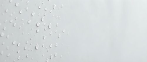 Water droplets on clean white surface creating fresh minimalist background with natural moisture condensation pattern for modern design projects.