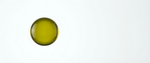 Golden yellow olive oil drop on white background isolated for culinary design and cooking concepts.