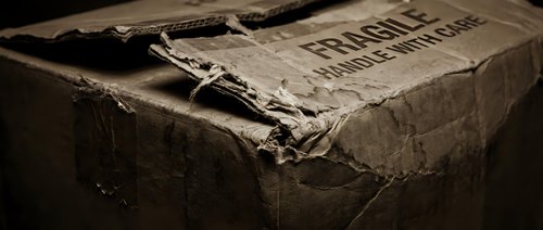 Vintage weathered cardboard box with torn edges and aged paper texture in sepia tones, perfect for antique storage and nostalgic design projects.