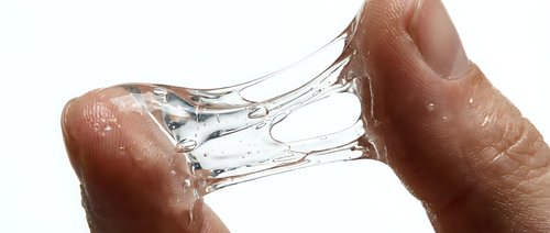 Hands holding transparent glass with water splashing against white background, isolated design element for commercial use.