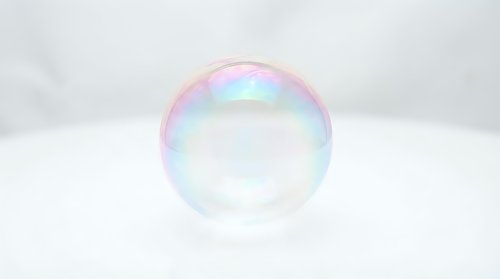 Single soap bubble with rainbow iridescent colors floating against clean white background for design projects and commercial use.