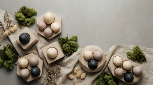 Natural organic eggs in cardboard cartons with fresh broccoli and dried flowers on neutral background for healthy cooking and farm fresh produce concepts.