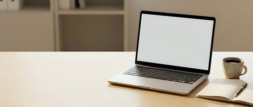 Modern laptop with blank white screen on wooden desk beside coffee cup in minimalist office workspace for business presentations and remote work.