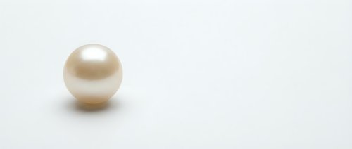 Single cream colored pearl on white background isolated for jewelry design and luxury accessories marketing materials.